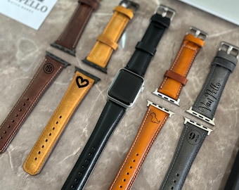 Puede incluir: Una variedad de correas de reloj de cuero en varios colores, incluyendo marrón, negro y beige. Algunas correas presentan diseños grabados como un corazón, un dinosaurio y la marca "VanPello". También se muestra un Apple Watch plateado.