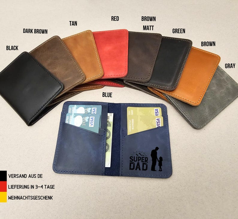 Peut inclure: Un portefeuille en cuir bleu avec deux fentes pour cartes et une poche pour l'argent. Le portefeuille porte l'inscription "SUPER DAD" et une silhouette d'un p&egrave;re et d'un enfant. Le portefeuille est pr&eacute;sent&eacute; avec d'autres portefeuilles de diff&eacute;rentes couleurs, notamment noir, marron, beige, rouge, vert et gris.