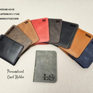Peut inclure: Une s&eacute;lection de porte-cartes personnalis&eacute;s dans diff&eacute;rentes couleurs, notamment noir, marron fonc&eacute;, beige, rouge, gris, vert, marron et bleu. Les porte-cartes sont en cuir et ont un design simple. Le texte "Porte-cartes personnalis&eacute;" est imprim&eacute; sur le devant des porte-cartes. Le texte "Leon Schneider" est imprim&eacute; sur le devant d'un des porte-cartes.