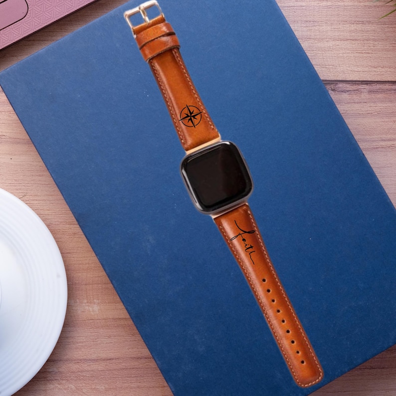 May include: A brown leather watch band with a compass and the word "Faith" engraved on it.