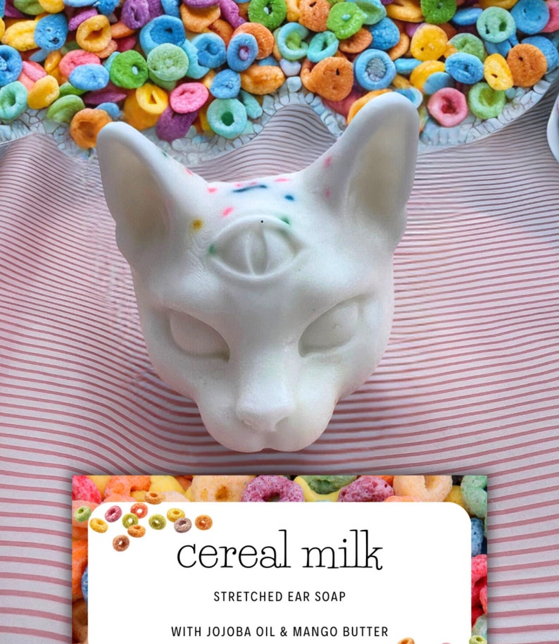 a white bar of soap with rainbow sprinkles shaped like a cat. It smells like fruit loops and is a specialty handmade soap for stretched ears. Stretched Ear deodorant stretched ear smell,why do my stretched ears stink? Stretched ear conditioning cream
