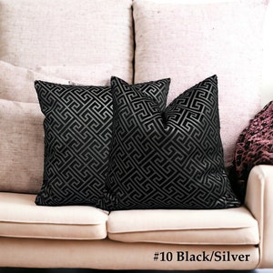 May include: Two black and silver patterned throw pillows with a geometric design on a light beige couch. #10 Black/Silver