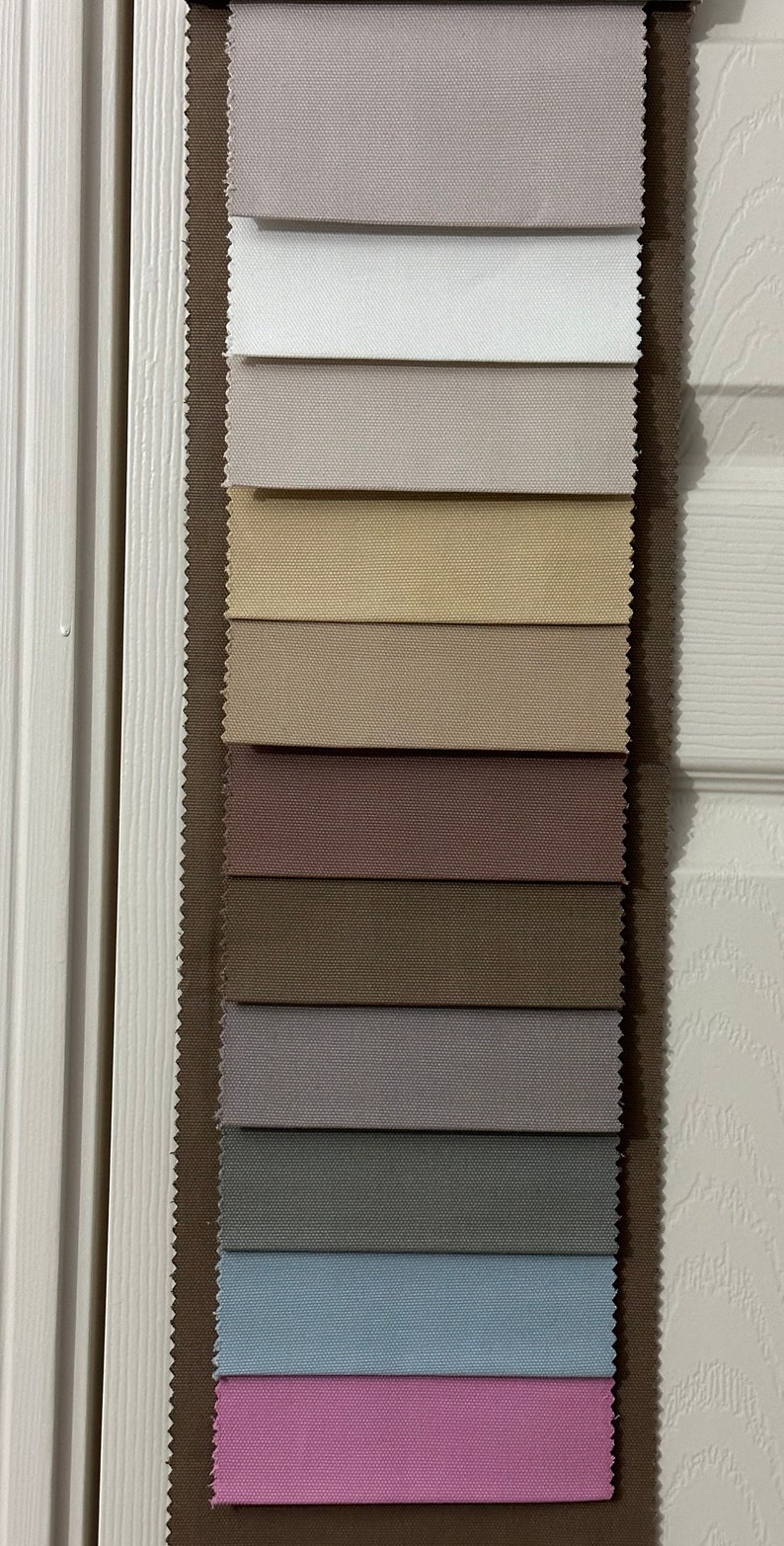 May include: A fabric swatch book with 14 different fabric samples. The samples are in various shades of beige, brown, pink, and blue.