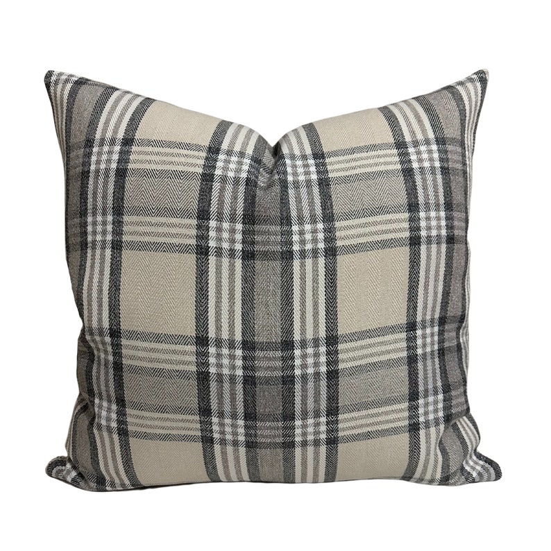 May include: A beige and black plaid throw pillow with a square shape.