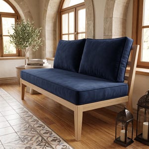 K&ouml;nnte beinhalten: Ein Zweisitzer-Sofa mit einem hellen Holzrahmen und zwei weichen, tief dunkelblauen Polstern. Sitzfl&auml;che und R&uuml;ckenlehne sind mit einem glatten, einfarbigen Stoff bezogen und ruhen auf vier geraden Holzbeinen in nat&uuml;rlicher, heller Optik.