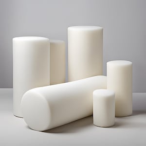 May include: Five white foam cylinders of varying sizes. The cylinders are arranged in a staggered formation on a white surface.