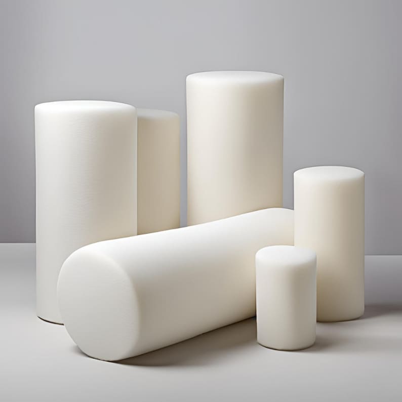 May include: Five white foam cylinders of varying sizes. The cylinders are arranged in a staggered formation on a white surface.