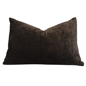 May include: A brown velvet pillow with a slightly textured surface.