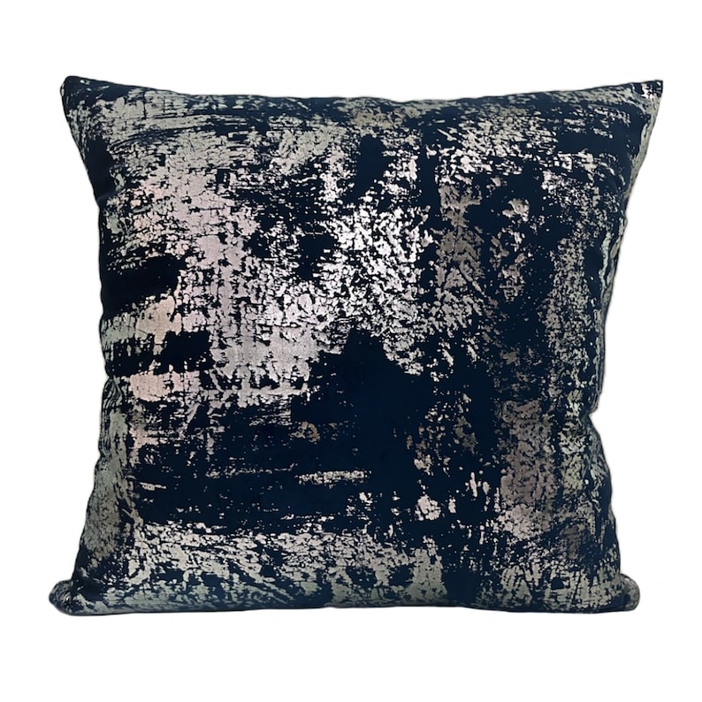 May include: A navy blue throw pillow with a silver metallic abstract design. The pillow has a square shape and a soft, plush texture.