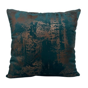 May include: A teal blue throw pillow with a metallic gold abstract pattern. The pillow is made of a soft, plush fabric.