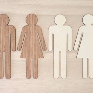 May include: Four wooden cutout figures of people, two are brown and two are white. The figures are all the same size and shape, and they are arranged in a row.