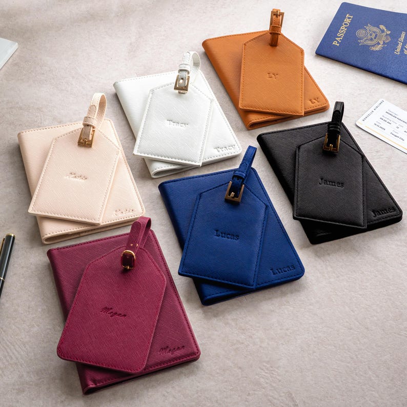 Puede incluir: Un surtido de accesorios de viaje personalizados, que incluyen fundas para pasaportes y etiquetas para equipaje. Los art&iacute;culos son de varios colores: blanco, beige, azul, negro y burdeos. Cada etiqueta est&aacute; grabada con un nombre, y los portapasaportes tienen un dise&ntilde;o a juego.