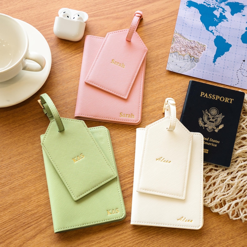 Puede incluir: Un conjunto de accesorios de viaje, que incluyen fundas para pasaporte y etiquetas para equipaje en rosa pastel, verde claro y crema. Tambi&eacute;n hay un pasaporte negro. Las etiquetas de equipaje y los portapasaportes est&aacute;n personalizados con nombres.