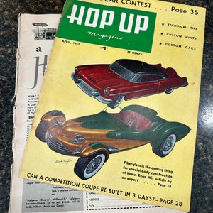 May include: A vintage magazine cover featuring a red and black custom car with the title "Hop Up Magazine" and the text "Custom Car Contest" and "Page 35".