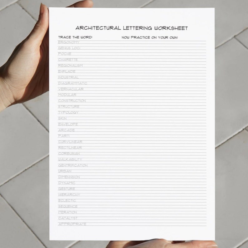 Image of someone holding the Architectural Lettering Worksheet in their hands in front of a white wall.