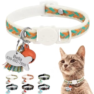 May include: A white cat collar with a braided orange and green design. The collar has a white buckle and a silver bell charm with a fish-shaped tag that reads "Bella 639-892-7850". The collar is shown with a cat wearing it and several other collars in different colours.
