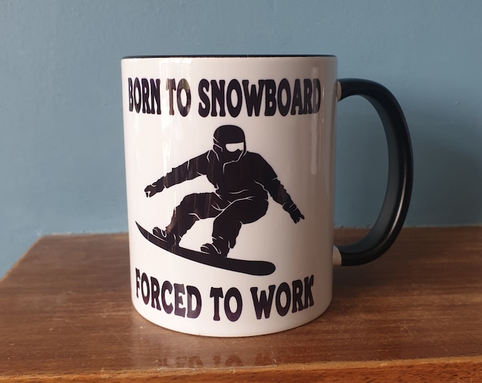 Snowboarding mug with humourous theme and the wording 'Born to Snowboard, Forced to work'