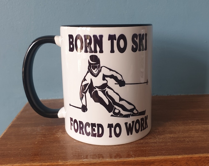 Skiing mug with humourous theme and the wording 'Born to Ski, Forced to work'