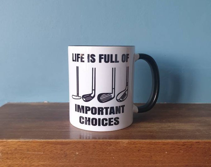A lovely golf themed mug with black handle and black inside with the wording- 'Life is full of important choices'