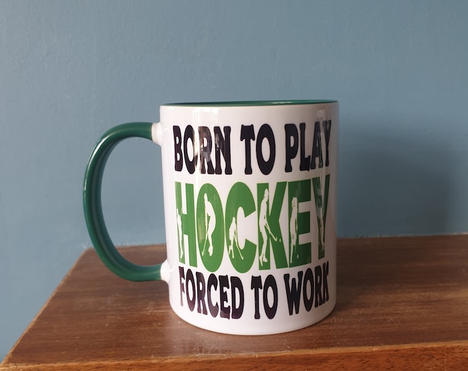 Hockey mug with humourous theme and the wording 'Born to play Hockey, Forced to work'