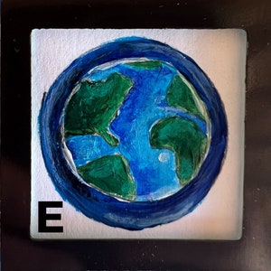 May include: A hand-painted blue and green globe with a white background and the letter "E" in the bottom left corner.