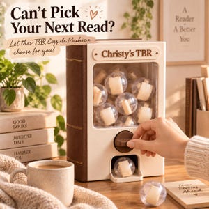 May include: A book-shaped capsule machine with a cream-colored front and brown sides. The front features the text 'Christy's TBR' above a clear window filled with small plastic spheres containing rolled paper. A brown dial sits below the window.