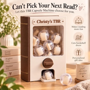 May include: A cream and brown book-shaped capsule machine with the text Christy's TBR. The machine features a clear front panel filled with transparent spheres containing rolled paper, a brown turning knob, and a dispensing slot at the bottom.