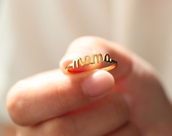 Könnte beinhalten: Ein goldener Ring mit dem Wort "mama" in Kursivschrift.