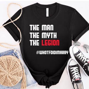 May include: Black t-shirt with white text that reads "The Man The Myth The Legion #WHOTFDIDIMARRY". The text "Legion" is in red.