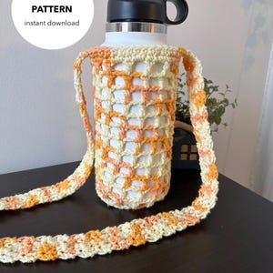 May include: Crochet pattern for a water bottle holder with a strap. The holder is made with a white and orange yarn and has a square pattern. The strap is made with the same yarn and has a striped pattern.