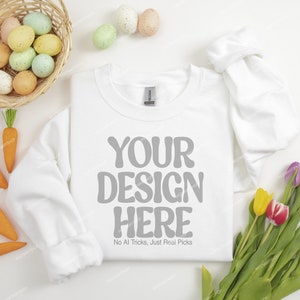 May include: White sweatshirt with the text "YOUR DESIGN HERE" and the phrase "No AI Tricks, Just Real Picks" printed on the front. The sweatshirt is surrounded by Easter-themed decorations, including pastel-colored eggs and carrots.