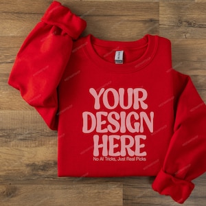 May include: Red sweatshirt with the text "YOUR DESIGN HERE" and the phrase "No AI Tricks, Just Real Picks" printed on the front.