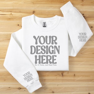 May include: White sweatshirt with long sleeves and a crew neck. The front of the sweatshirt has the text "YOUR DESIGN HERE" in gray. The text "No Al Tricks, Just Real Picks" is printed below the main text. The sleeves have the text "YOUR DESIGN HERE" printed in gray.
