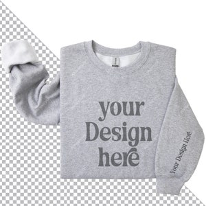 May include: A gray sweatshirt with the text "your design here" printed on the front. The sweatshirt is folded in half and the sleeves are rolled up.