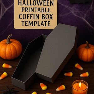 Può includere: Una scatola grigia a forma di bara con il testo "HALLOWEEN PRINTABLE COFFIN BOX TEMPLATE" su un cartello marrone. La scena include zucche, caramelle a forma di mais, una candela e un ragno, il tutto su una superficie di legno, con uno sfondo viola.