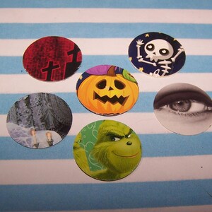 Puede incluir: Seis pegatinas redondas con temática de Halloween con varias imágenes, incluyendo una calabaza, un esqueleto, un Grinch, un ojo, una escena de invierno y una cruz roja y negra.