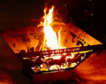 May include: A metal fire pit with a personalized inscription "Joseph's Firepit" and a silhouette of horses. The fire pit is filled with burning flames.