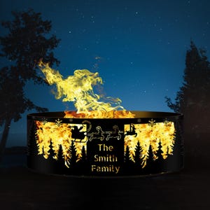 May include: A black metal fire pit with a cut-out design of a winter scene, including a sleigh with Santa Claus and reindeer, pine trees, and snowflakes. The fire pit is lit and the flames are visible. The text "The Smith Family" is inscribed on the fire pit.