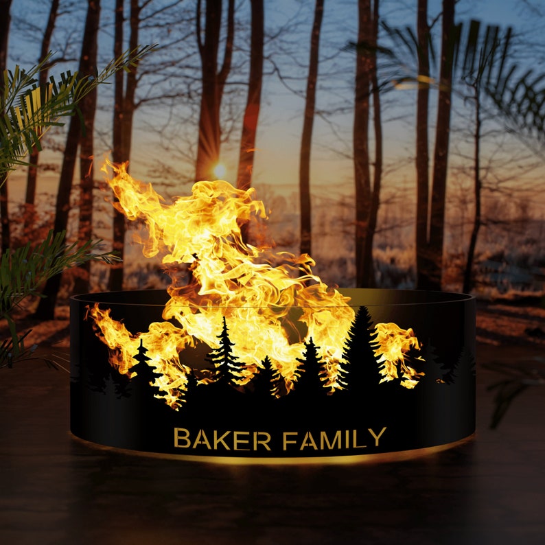 May include: Black metal fire pit with a silhouette of a forest and the text "BAKER FAMILY" on the front. The fire pit is lit and flames are visible.