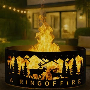 Peut inclure: Un foyer rond en métal noir avec un motif de silhouette de montagne et de forêt. Les mots "A Ring of Fire" sont découpés dans le métal. Des flammes vives sont visibles à l'intérieur du foyer, avec un jardin en arrière-plan.