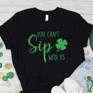 May include: Black t-shirt with green shamrock and the text "You can't Sip with us".