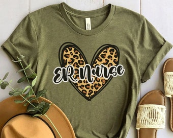 May include: Olive green t-shirt with a leopard print heart and the text "ER Nurse" in black.