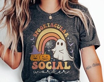 May include: A gray t-shirt with a rainbow, ghost, and pumpkins. The text on the shirt reads "Spooktacular Social Worker".