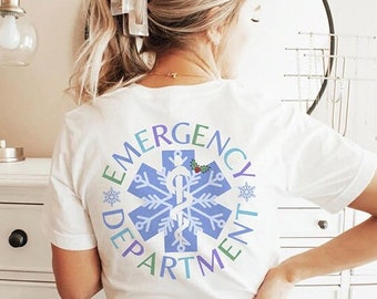 May include: White t-shirt with a blue snowflake and a snake design in the center. The design is surrounded by the words "Emergency Department" in a colorful circle.