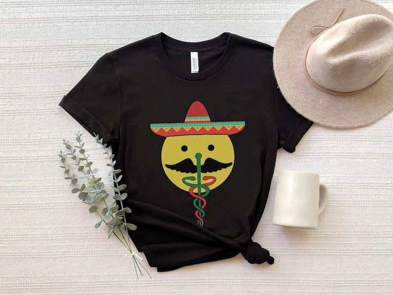K&ouml;nnte beinhalten: Schwarzes T-Shirt mit einem gelben Smiley, der einen roten, gelben und gr&uuml;nen Sombrero tr&auml;gt. Der Smiley hat einen Schnurrbart und eine gr&uuml;ne Schlange als Nase.