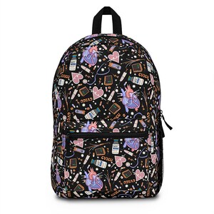 K&ouml;nnte beinhalten: Schwarzer Rucksack mit einem bunten Muster aus Herzen, medizinischen Ger&auml;ten und dem Wort "CVICU", das sich wiederholt.
