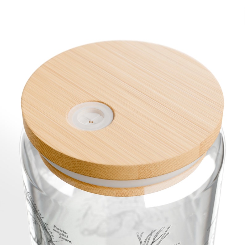 May include: A clear glass jar with a bamboo lid and a white silicone seal. The jar has a black and white illustration of a plant on the side. The lid has a small hole in the center.