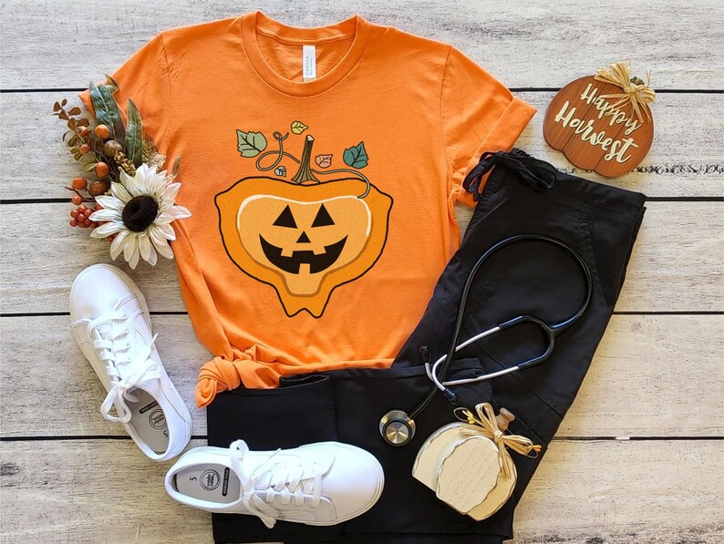 May include: Orange t-shirt with a jack-o'-lantern graphic and the text "Happy Harvest".