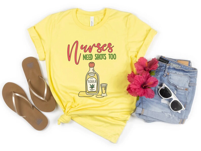 May include: Yellow t-shirt with the text "Nurses need shots too" and a cartoon image of a bottle of tequila and a shot glass.