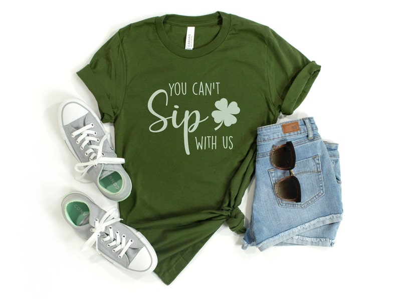 May include: A green t-shirt with the text "You Can't Sip With Us" and a four-leaf clover graphic.